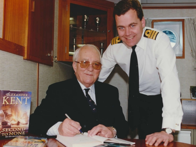 Douglas Reeman signing books during visit to HMS Kent in 2000 (photo courtesy Royal Navy).